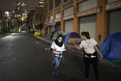 Volunteers count homeless people on a dark street on Skid Row during the 2015 Greater Los Angeles Homeless Count conducted by the Los Angeles Homeless Services Authority (LAHSA) in Los Angeles on Jan. 29, 2015.