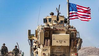 Image: A U.S. soldier sits atop an armoured vehicle during a demonstration 