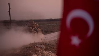 Image: A Turkish armored vehicle prepares to cross the border into Syria on