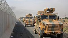 Turkish armored vehicles drive along the Turkish side of the border as they