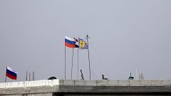 Image: Russian, Syrian and Manbij military council flags flutter near Manbi