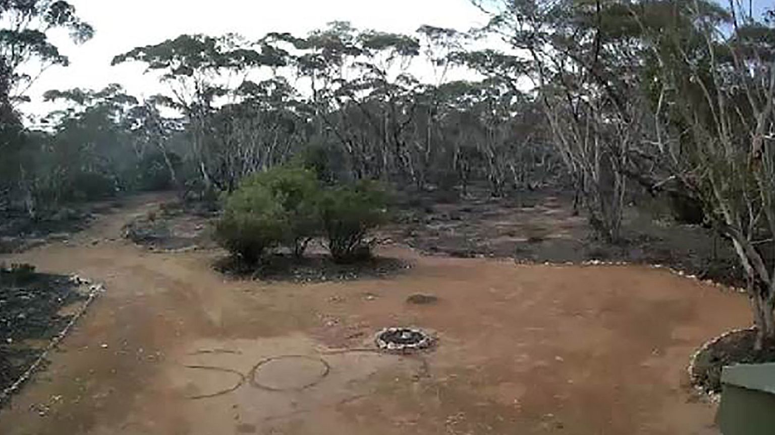 Image: An SOS sign written in the dirt by Australian woman Deborah Pilgrim 