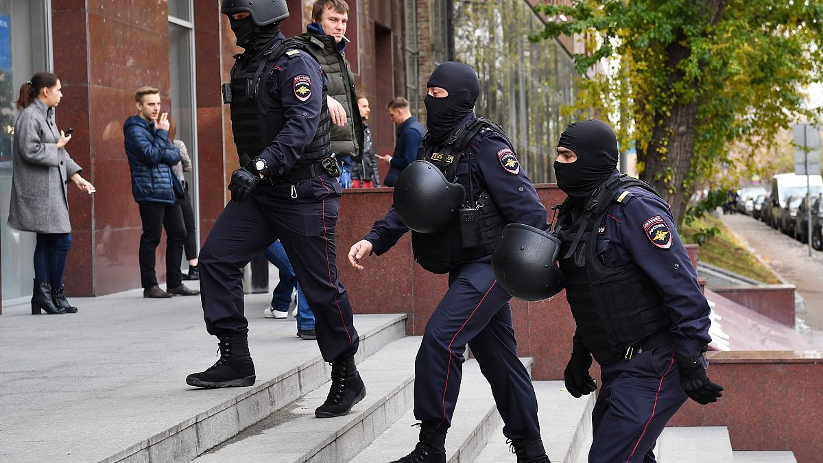Image: Russian police officers walk to enter a business centre, which house