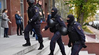 Image: Russian police officers walk to enter a business centre, which house