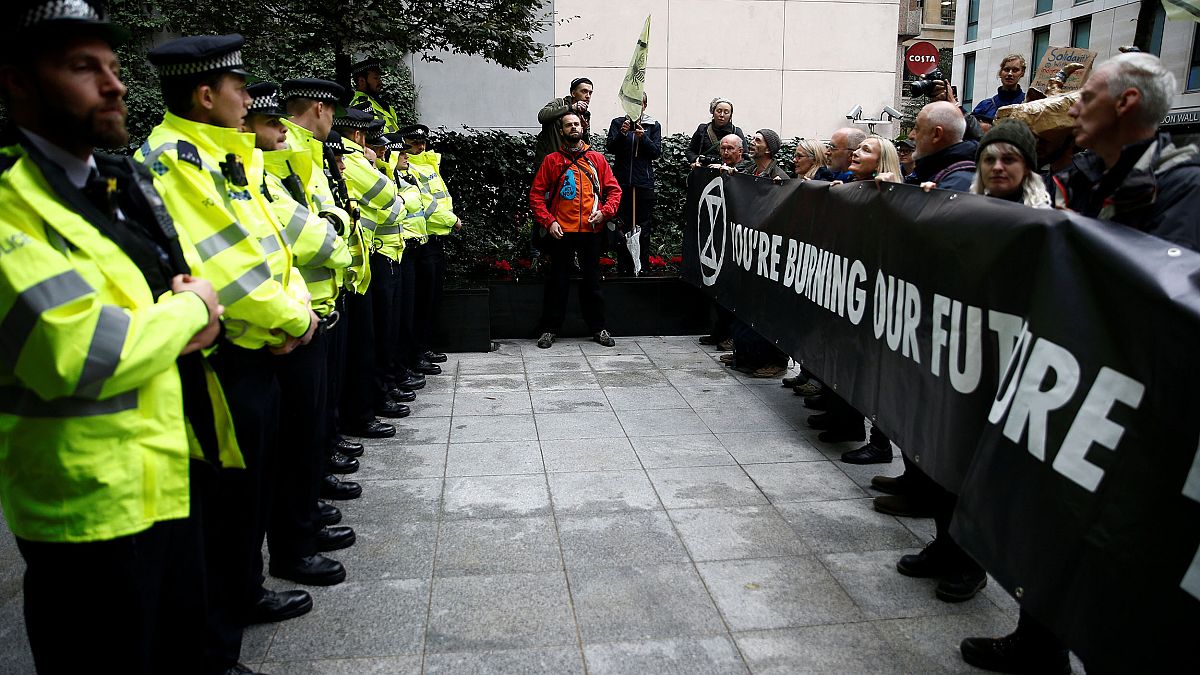 Image: Protesters hold a banner outside the BlackRock office during an Exti