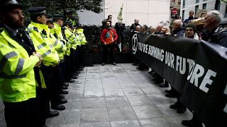 Image: Protesters hold a banner outside the BlackRock office during an Exti