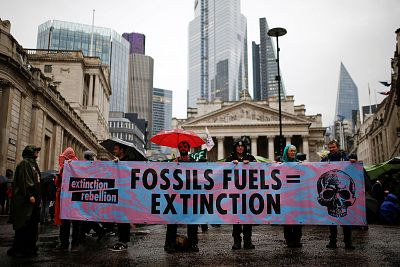 Protesters hold a banner as they block the road during an Extinction Rebellion demonstration at in central London on Monday.