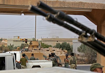 Turkey-backed Syrian fighters gather on the road between the Syrian towns of Tal Abyad and Kobani on the Turkish border on Wednesday as Turkey and its allies continue their assault on Kurdish-held border towns in northeastern Syria.