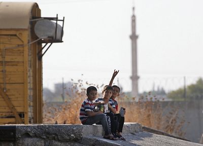 Children gesture to the camera in Akcakale Sanliurfa province, southeastern Turkey, at the border with Syria on Friday.