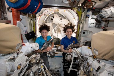 NASA astronauts Jessica Meir, left, and Christina Koch are inside the Quest airlock preparing the U.S. spacesuits and tools they will use on their first spacewalk together on the International Space Station.