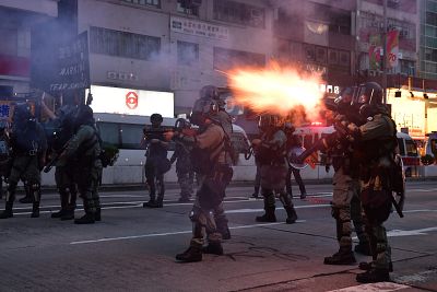 Riot police fire tear gas against protesters during a march in the Kowloon district in Hong Kong on Sunday.
