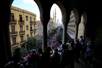 Demonstrators watch crowds from a balcony during anti-government protests in Beirut, Lebanon, on Oct. 20, 2019.
