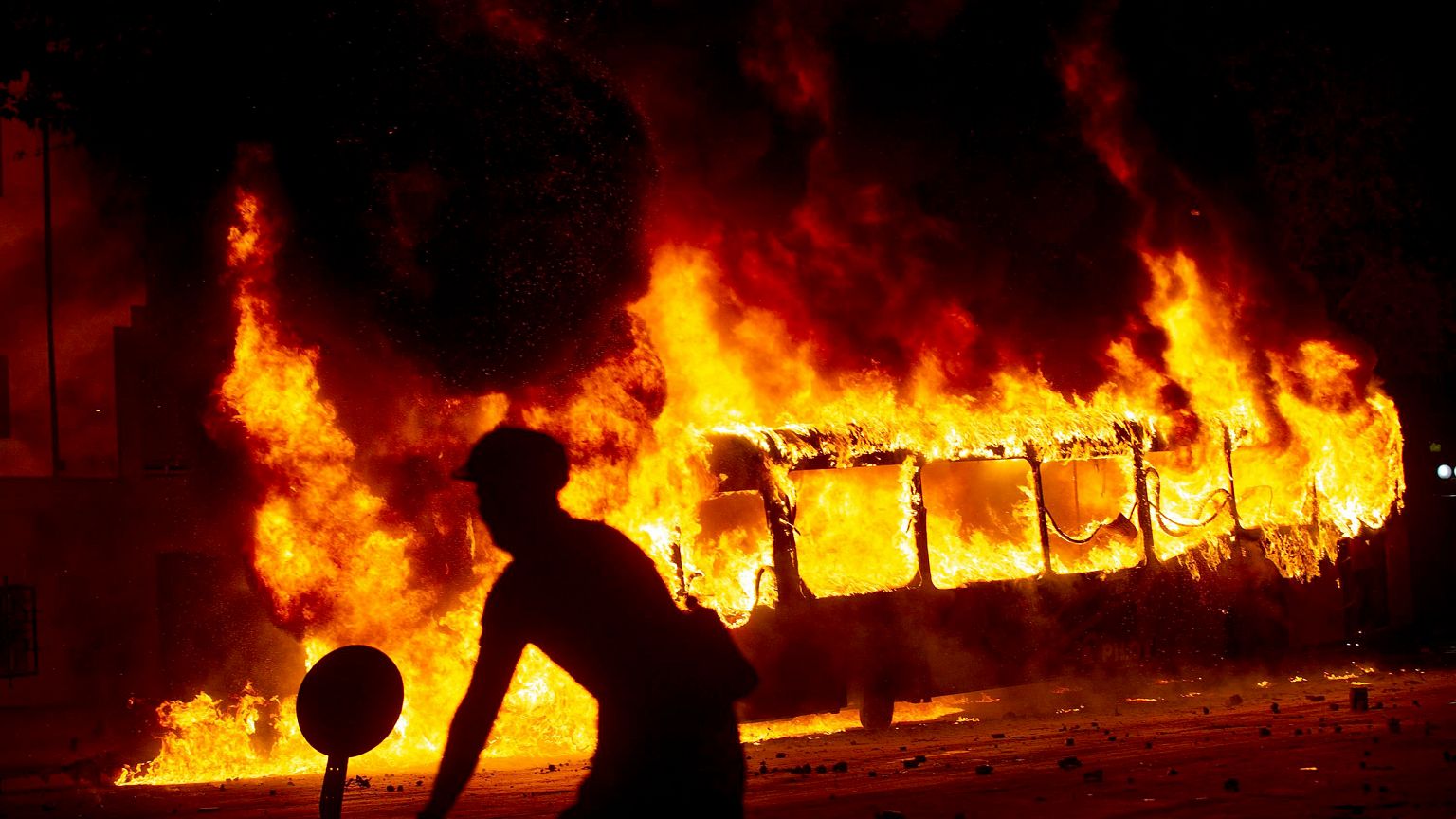Image: A bus burns in downtown Santiago following a mass fare-dodging prote