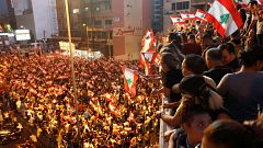 Image: Demonstrators carry national flags as they stand on a bridge during 
