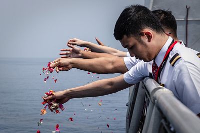 Colleagues of victims of the crashed Lion Air flight throw flowers from the deck of an Indonesian Navy at the site of the crash in waters off Indonesia on Nov. 6, 2018.
