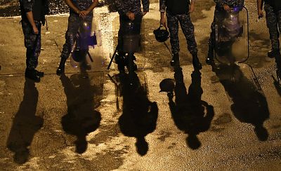 Lebanese riot policemen stand guard on a road leading to the government palace, in Beirut, Lebanon, Wednesday. 