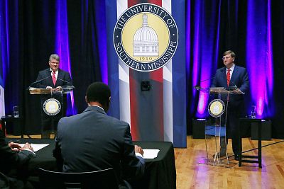 Democratic State Attorney General Jim Hood, left, and Republican Lt. Gov. Tate Reeves, right, listen to a question from one of the two moderators during the first televised gubernatorial debate at the University of Southern Mississippi in Hattiesburg, Miss. on Oct. 10, 2019.