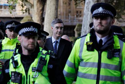 Police officers escort Britain\'s Leader of the House of Commons Jacob Rees-Mogg as he leaves Parliament. 