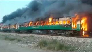 Image: The fire burns after a gas canister train passengers were using to c