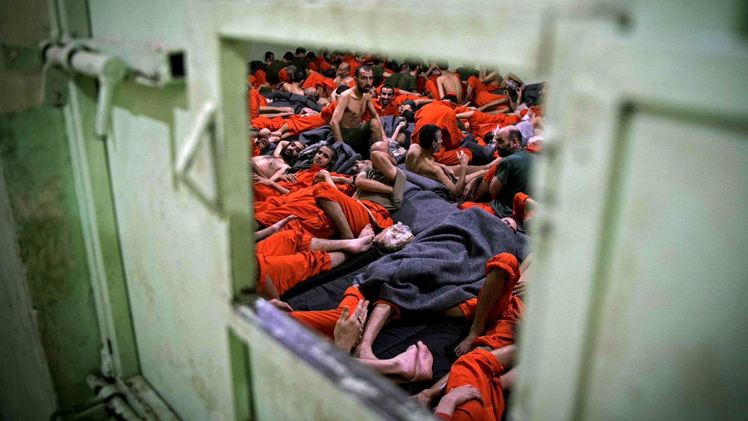 Image:Men suspected of being affiliated with ISIS sit in a prison cell in H
