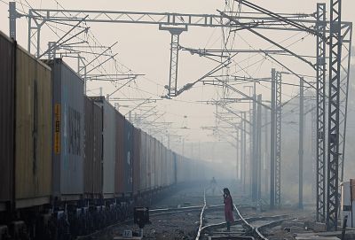 A girl waits to cross the railway line on a smoggy morning in New Delhi, India, Nov. 5, 2019.