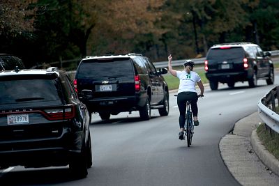 Juli Briskman shows her middle finger as a motorcade with President Donald Trump departs Trump National Golf Course in Sterling, Va. on Oct. 28, 2017.