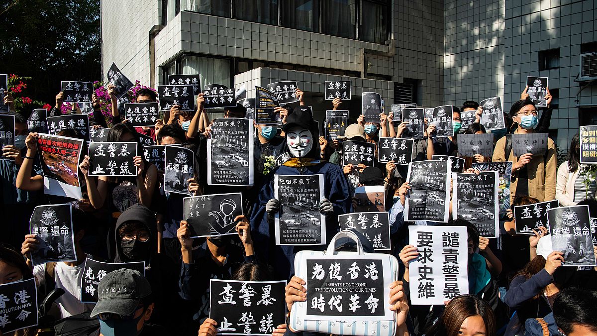 Image: Protesters hold a photos of Chow Tsz-Lok during a memorial flash mob