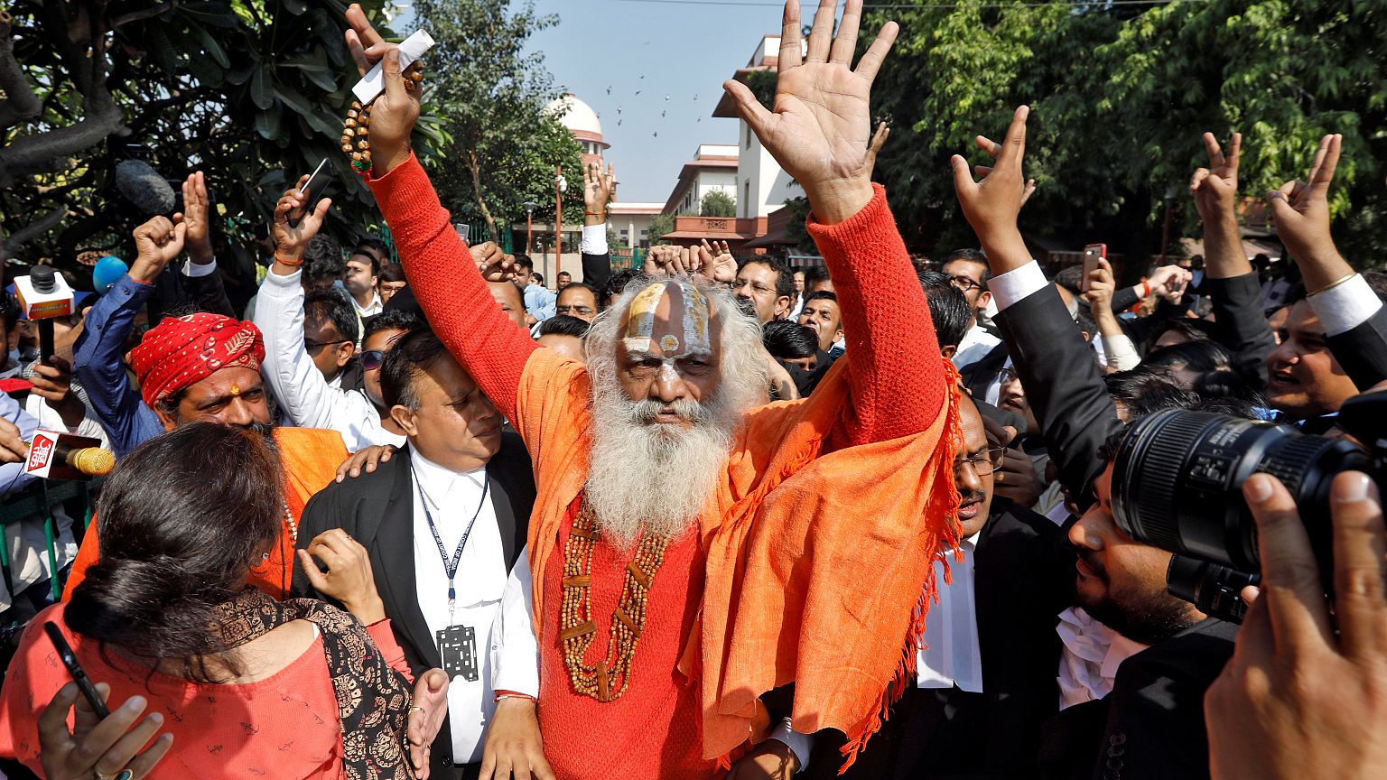 Image: Mahant Dharam Das, chief Priest of Nirmohi Akhara, celebrates after 