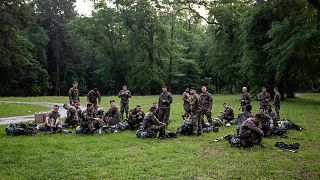 Army Ranger trainees rest after the 12-mile march during which they wore se
