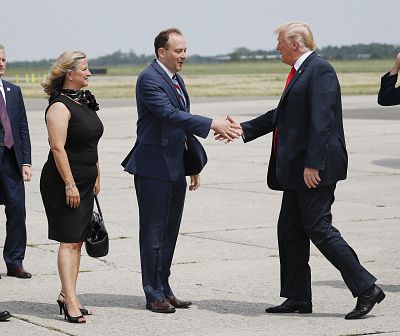 President Donald Trump is greeted on the tarmac by Rep. Lee Zeldin, R-N.Y., center, and Maria Moore, left, Mayor of Westhampton Beach, NY., during his arrival at Francis S. Gabreski Airport in Westhampton, N.Y., on Aug. 17, 2018.