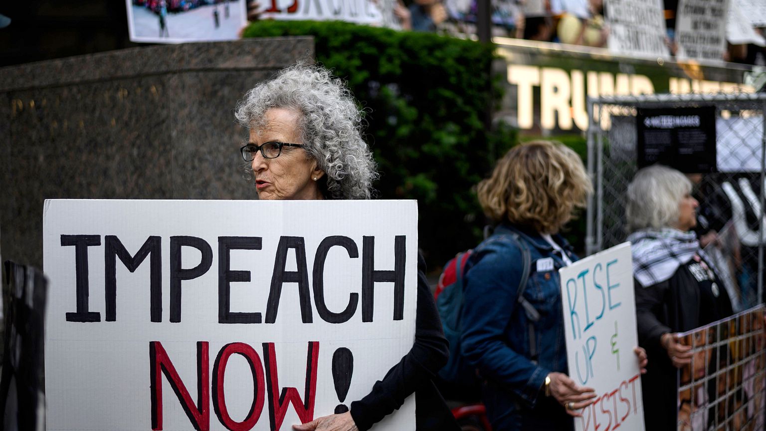 A demonstrator with a sign reading "Impeach now" takes part in Trumps Birth