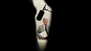 Image: National Security Adviser John Bolton listens in the Oval Office on