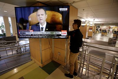 University of Utah student Suyog Shrestha turns on a television at the school\'s student union as Rep. Adam Schiff speaks during an impeachment hearing on Nov. 13, 2019.