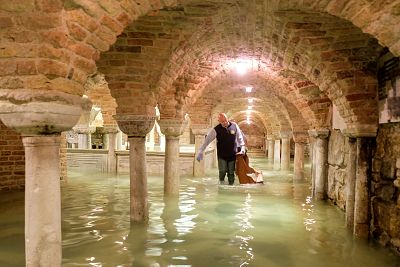 A man wades in the flooded crypt of St Mark\'s Basilica on Wednesday. 