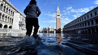 Image: A woman walks through the flood St. Mark's Square in Venice on Nov. 