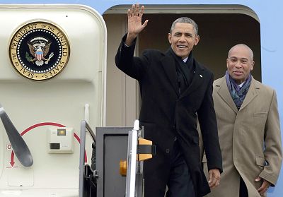 President Barack Obama waves as he is followed by Massachusetts Gov. Deval Patrick, right, upon his arrival on Air Force One at Logan Airport in Boston on March 5, 2014.