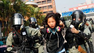 Image: A protester is detained by riot police while attempting to leave the