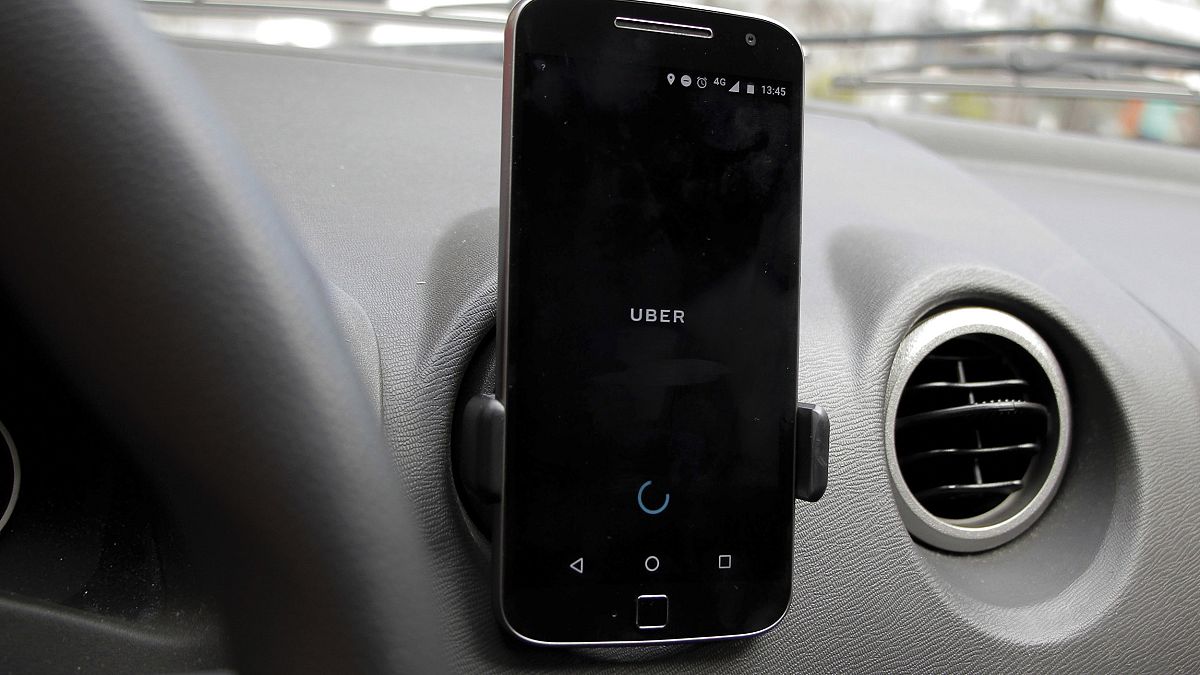 Image: A smartphone showing the Uber app is display inside a car in Brazil 
