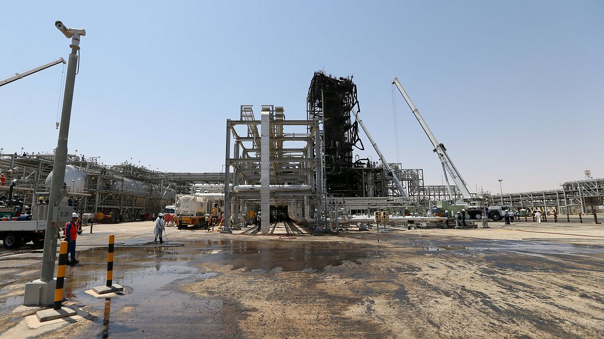 Image: Workers are seen at the damaged site of Saudi Aramco oil facility in