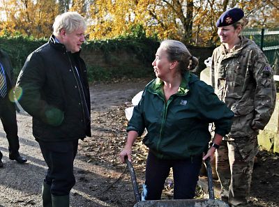 Prime Minister Boris Johnson talks with a local woman pushing a wheelbarrow during a visit to Stainforth to see the recent flooding.