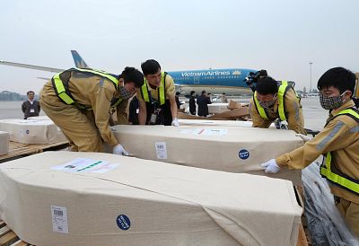 Airport workers unload coffins, carrying some of the 39 bodies found on a truck container in Britain, from an airplane for homeland repatriation at Noi Bai airport in Hanoi, Vietnam on Nov. 27.