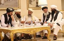 Image: Senior Afghans gather during talks with the Taliban in the Qatari ca