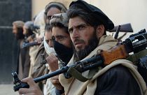 Image: Afghan alleged former Taliban fighters carry their weapons before ha