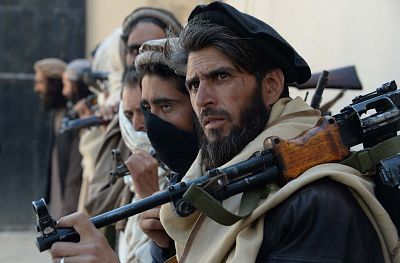 Afghan alleged former Taliban fighters carry their weapons before handing them over as part of a government peace and reconciliation process.