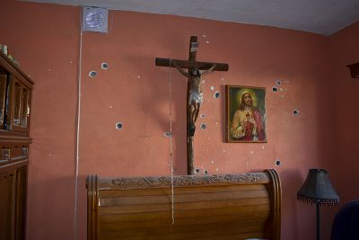 A wall of the room of a home is riddled with bullet holes after a gun battle between Mexican security forces and suspected cartel gunmen, in Villa Union, Mexico, Saturday, Nov. 30, 2019.