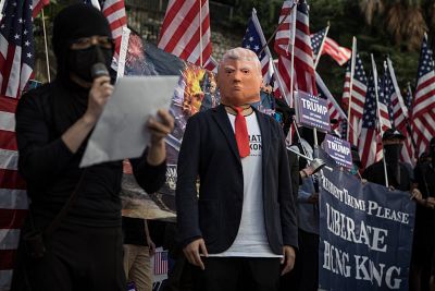 A pro-democracy protester wears a face mask of President Donald Trump during a March of Gratitude rally to say thank you to the United States for their support on Sunday.