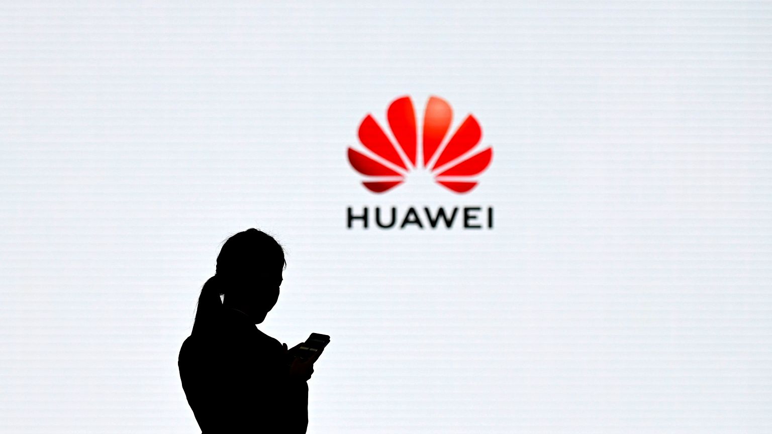 Image: An employee uses her phone at the Huawei Digital Transformation Show