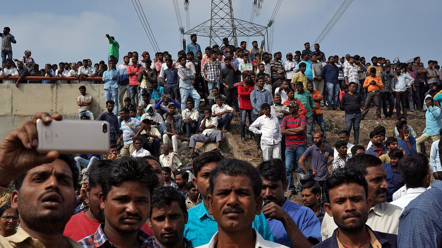 Image: People gather at the site where police shot dead four men suspected 