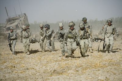 Task Force Shadow Medivac flight medic Sgt. Cole Reece escorts three wounded soldiers from the battlefield to the chopper after an IED blasted their MATV vehicle in Kandahar Province, Afghanistan in 2010. 