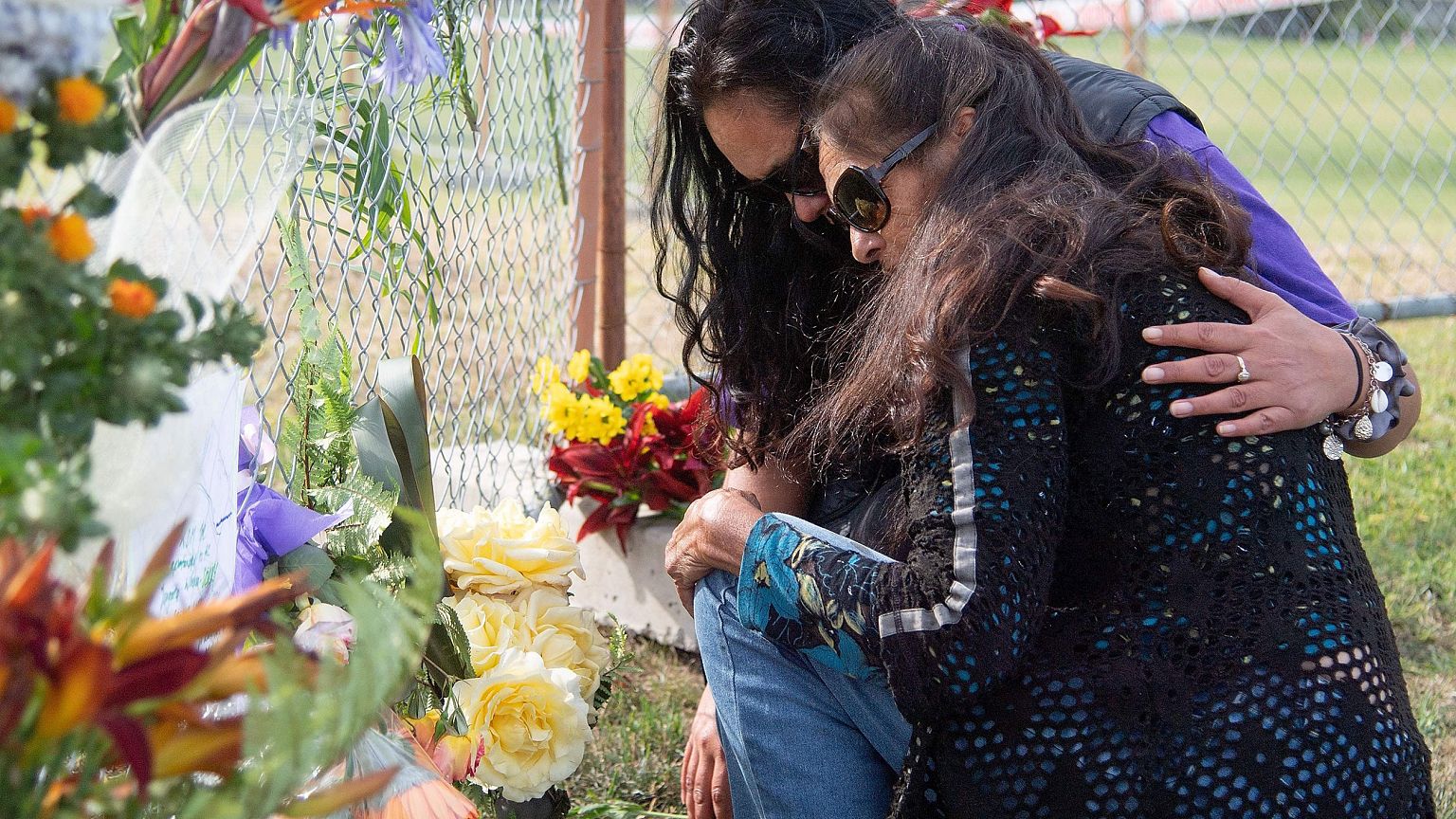 Image: Bouquets of flowers are placed on the waterfront near White Island T